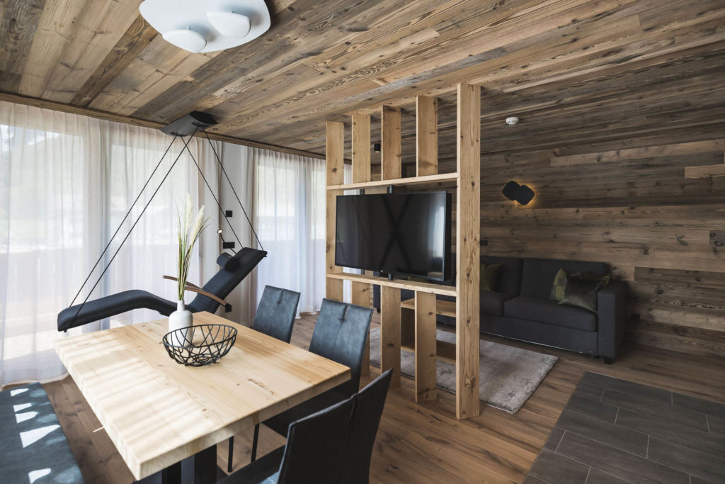 Moderner Wohnbereich mit Holzinterieur und Infrarothängeliege mit Bergblick im Apartment Kinigschworte