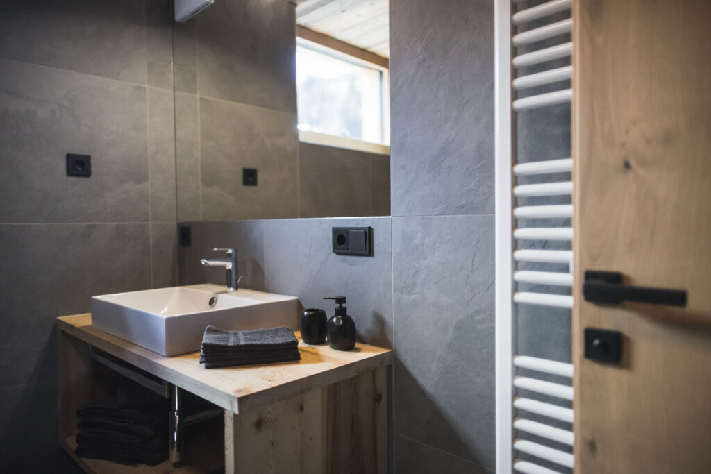 odernes Badezimmer mit Holzdetails im Apartment Kinigschworte